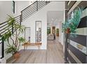 Bright entryway with modern staircase, bench, and view to living room at 577 Venice Ln, Sarasota, FL 34242