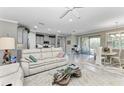 Open concept living room featuring a white sofa, modern furniture, and sliding glass doors at 123 Pescador Pl, Nokomis, FL 34275