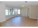 Bright living room featuring a large window, neutral tile flooring, and a white door at 6555 Connecticut Ave, Sarasota, FL 34243