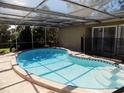 Screened-in pool with clear blue water and ample sunlight, steps leading into the pool at 6555 Connecticut Ave, Sarasota, FL 34243
