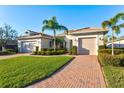 Beautiful two-story home with a brick driveway and lush landscaping at 5130 Tidewater Preserve Blvd, Bradenton, FL 34208
