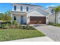 Two-story house with brown garage door, landscaping, and light-grey exterior at 2612 Star Apple Way, Sarasota, FL 34240