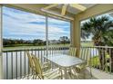 Outdoor patio boasts peaceful lake views, table, and chairs at 111 Woodbridge Dr # 202, Venice, FL 34293