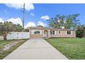 Tan house with white shutters, driveway, and landscaped lawn at 15 Tulane Rd, Venice, FL 34293