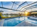 Enclosed pool area with patio furniture, offering sunset views at 8983 Baroque Ter, Sarasota, FL 34240