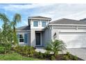 Two-story house with gray exterior, white garage door, and landscaped yard at 2528 Star Apple Way, Sarasota, FL 34240