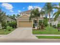 Two-story house with tan siding, a two-car garage, and landscaped yard at 12224 Longview Lake Cir, Bradenton, FL 34211