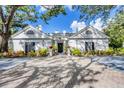 Elegant white home with black shutters and a brick driveway at 75 Osprey Point Dr, Osprey, FL 34229