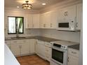 Bright kitchen with white cabinets and granite countertops at 144 Garden Ln, Sarasota, FL 34242