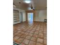 Spacious living room with terracotta tile floors and built-in shelving at 144 Garden Ln, Sarasota, FL 34242