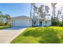 Ranch-style home with a two-car garage and lush lawn at 2814 Daphne Rd, North Port, FL 34288