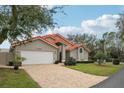 Tan house with orange tile roof and a large grassy yard at 5296 White Sand Ne Cir, St Petersburg, FL 33703