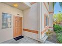 Condo building entrance with orange door and landscaping at 3956 Mediterranea Cir # 412, Sarasota, FL 34233