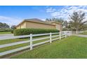 Home features a large garage with a white fence at 8480 Big Buck Ln, Sarasota, FL 34240