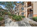 Exterior view of a well-maintained multi-story building with walkways and mature trees at 4174 Central Sarasota Pkwy # 214, Sarasota, FL 34238