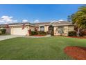 House exterior showcasing landscaping, a large lawn and American Flag at 4135 Dover E Dr, Bradenton, FL 34203