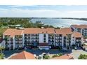 Aerial view of waterfront condo building with parking and landscaping at 1624 Stickney Point Rd # 401, Sarasota, FL 34231