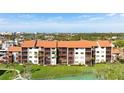 Aerial view of condo building, showing a tennis court and lush landscaping at 1624 Stickney Point Rd # 401, Sarasota, FL 34231