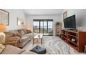 Living room with water views, comfy seating, and large sliding doors at 1624 Stickney Point Rd # 401, Sarasota, FL 34231