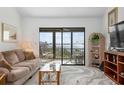 Living room features sliding doors to balcony and water views at 1624 Stickney Point Rd # 401, Sarasota, FL 34231