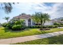 Single-story house with lush landscaping and a palm tree in front at 455 Park Trace Blvd, Osprey, FL 34229