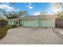 Front exterior of home showing a large concrete driveway and light green painted garage doors at 611 Mobile Rd, Venice, FL 34293