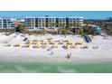 Beachfront property with numerous yellow umbrellas and lounge chairs at 915 Seaside Dr # 407, Sarasota, FL 34242