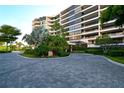 Elegant condo building entrance with paved driveway at 535 Sanctuary Dr # A202, Longboat Key, FL 34228