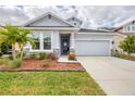 Two-story house with gray exterior, stone accents, and a two-car garage at 3819 Sunshine Pine Ave, Bradenton, FL 34203