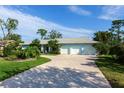 House exterior with a large driveway and lush landscaping at 7917 Broadmoor Pines Blvd, Sarasota, FL 34243