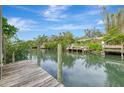 Wooden dock extends over calm canal waters, offering peaceful waterfront views at 444 Bellini Cir, Nokomis, FL 34275