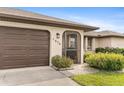 Front view of home with brown garage door and entryway at 1478 Navigator Rd, Punta Gorda, FL 33983