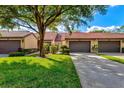 Front view of charming villa with 2-car garage and lush lawn at 6241 Timberlake Dr # D7, Sarasota, FL 34243