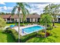 Community pool with lounge chairs and lush landscaping at 6241 Timberlake Dr # D7, Sarasota, FL 34243