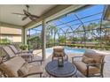 A covered patio with comfortable seating overlooks a screened-in pool and a view of the lake at 12240 Thornhill Ct, Lakewood Ranch, FL 34202