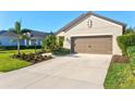 House exterior with driveway, landscaping, and palm trees at 12640 Coastal Breeze Way, Bradenton, FL 34211