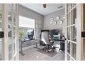 Bright home office features built-in desk and French doors at 12640 Coastal Breeze Way, Bradenton, FL 34211