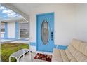 Light blue front door and comfortable seating area on the porch at 1565 Piedmont Rd, Venice, FL 34293