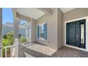 Covered front porch with dark teal door and white railings at 21205 Holmes Cir, Venice, FL 34293