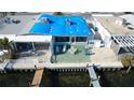 Aerial view of waterfront home with patio and dock at 23 Seaside Ct, Holmes Beach, FL 34217