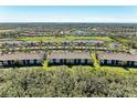 Aerial view of a community featuring a condo building with surrounding landscape and golf course at 6705 Grand Estuary Trl # 206, Bradenton, FL 34212