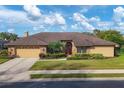 Charming single-story home with manicured lawn, mature landscaping, and brick accents at 4918 Fallcrest Cir, Sarasota, FL 34233