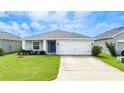 Single-story home with a two-car garage and well-manicured lawn at 16415 62Nd E Gln, Parrish, FL 34219