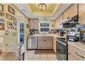 Modern kitchen with stainless steel appliances and wood cabinets at 2431 Golf Course Dr # 703, Sarasota, FL 34234