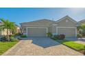 Two-car garage villa with paver driveway and landscaping at 7525 Alumni Trl, Sarasota, FL 34243