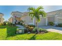 Tan two-car garage villa with landscaped walkway at 7525 Alumni Trl, Sarasota, FL 34243