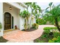 Front entry with a charming arched wooden door and a brick walkway at 1954 Datura St, Sarasota, FL 34239