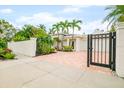 Front view of a home with a gated entrance and brick paver driveway at 1954 Datura St, Sarasota, FL 34239