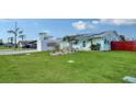 Cute teal home with a large yard and solar panels, seen from above at 1080 Piedmont Rd, Venice, FL 34293