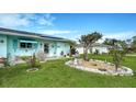 Well-manicured front yard with lush green grass, decorative landscaping, and solar panels enhances this home's appeal at 1080 Piedmont Rd, Venice, FL 34293